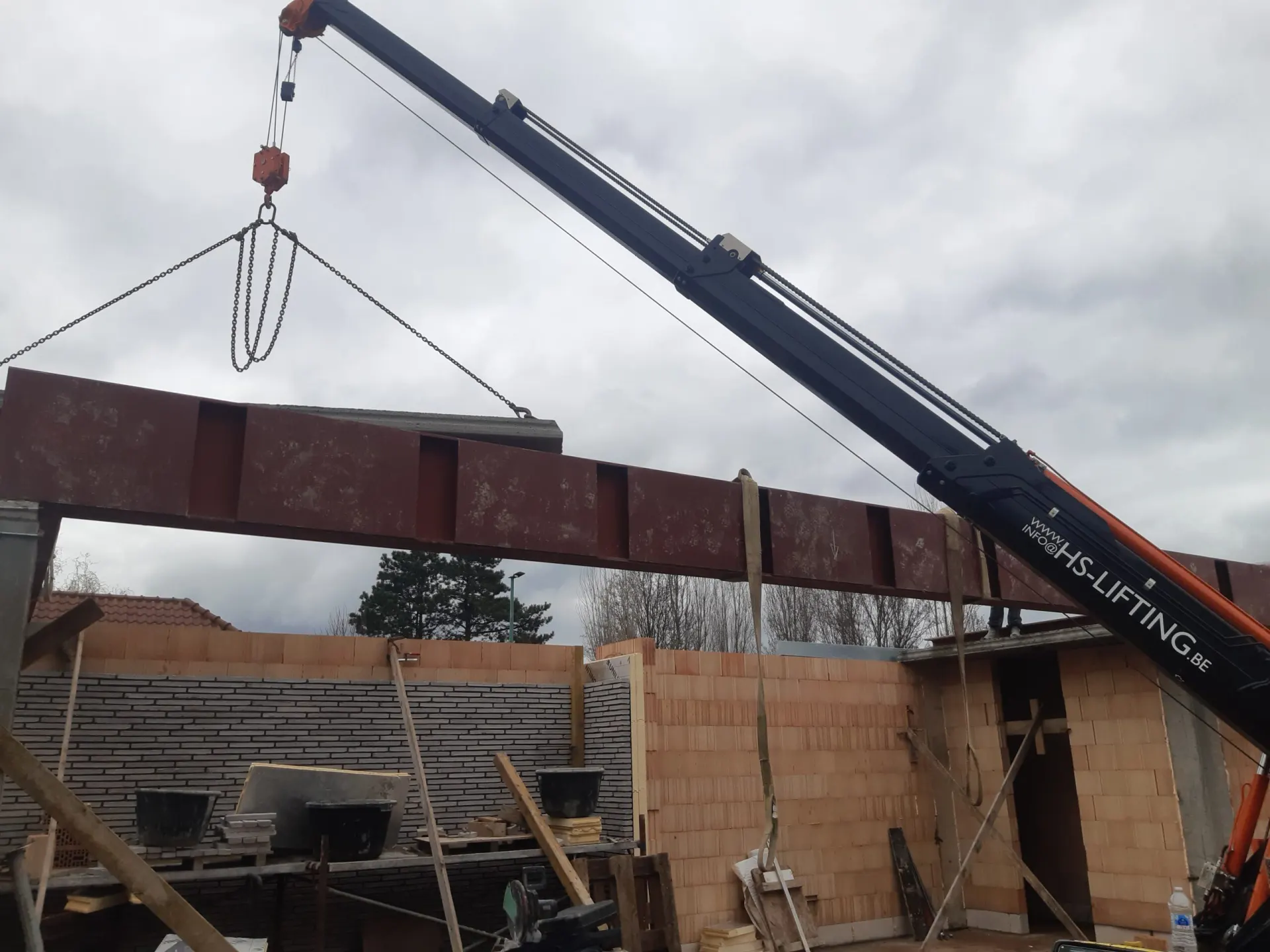 HS-lifting minihijskraan levert bouwmateriaal op hoogte